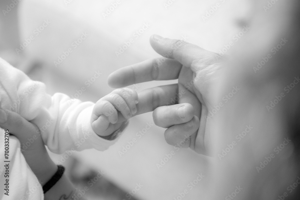 Les doigts du bébé qui tiennent la main de ses parents - obrazy, fototapety, plakaty 