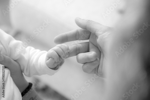 Les doigts du bébé qui tiennent la main de ses parents