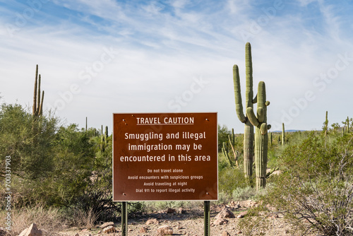 Sign near US - Mexican border wall reading Caution smuggling and illegal immigration in this area - Arizona photo