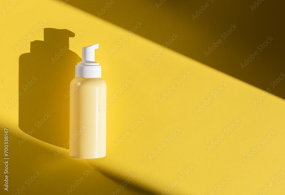 Yellow bottle with a dispenser on a yellow background. Yellow bottle with a dispenser on a yellow background.