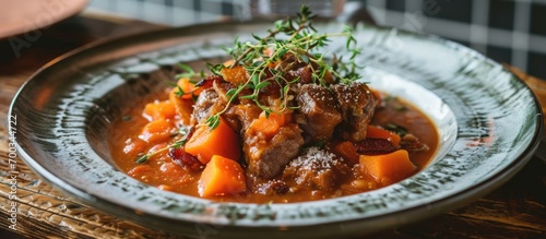 Veal cheeks with sweet potato puree, bacon, and beans in tomato-garlic sauce. photo
