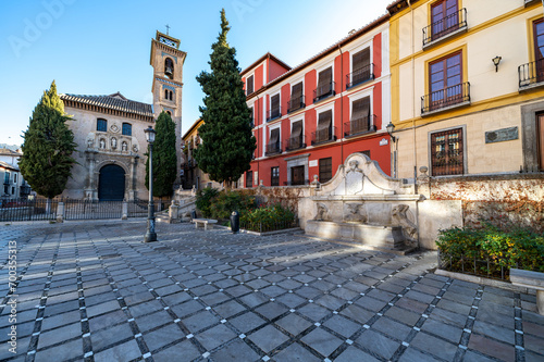 Granada, Spain; December-25, 2023: View of Plaza Nueva with the church of Santa Ana and the Pilar del Toro fountain, at the entrance to the Albaicin neighborhood in Granada (Spain)