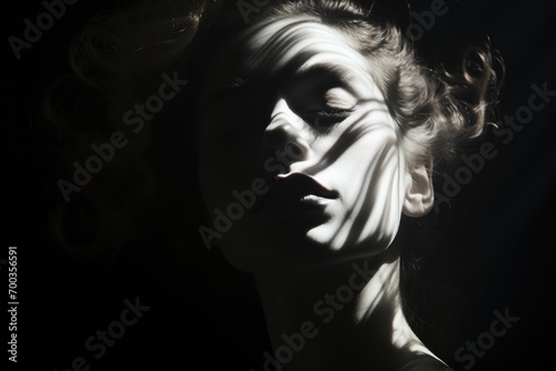 Black and white portrait of a woman with closed eyes with the play of light and shadows