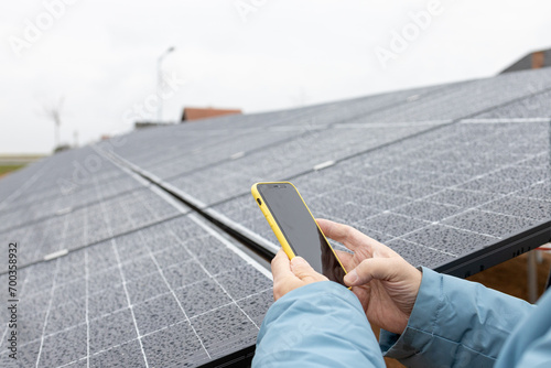 Close up of a mans hands making a photo of solar power panels. Renewable energy. Sustainable resources.