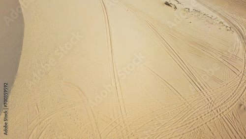 Dense of tracks made by pickup trucks, four-wheeled motorcycle driving on large sand dunes hills at Bau Trang, Bac Binh, Binh Thuan, Vietnam, scenic desert-like landscape travel destination