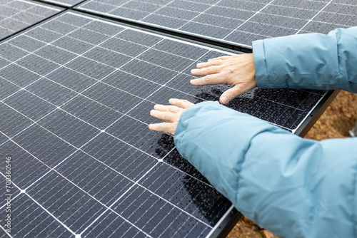 Close up of mans hands above solar power panels. Renewable energy. Sustainable resources.