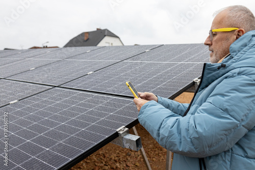 Close up of a mans hands making a photo of solar power panels. Renewable energy. Sustainable resources.