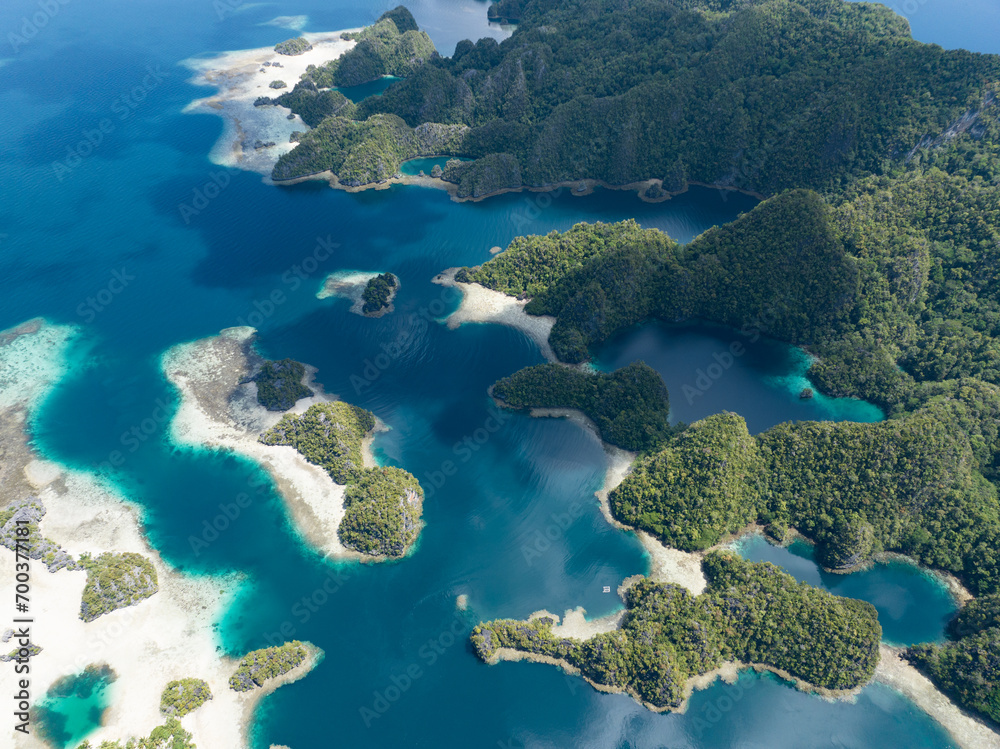 Limestone islands rise from the impressive seascape in Misool, Raja Ampat, Indonesia. These scenic islands' coral reefs, and the surrounding seas, support extraordinary marine biodiversity.