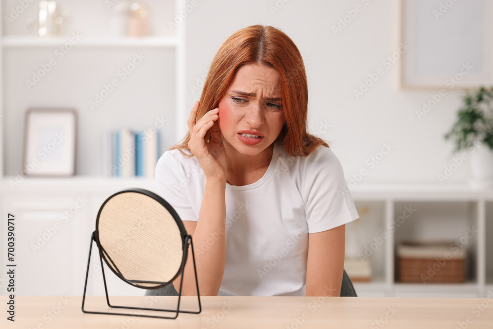 Suffering from allergy. Young woman with mirror checking her face at home Suffering from allergy. Young woman with mirror checking her face at home
