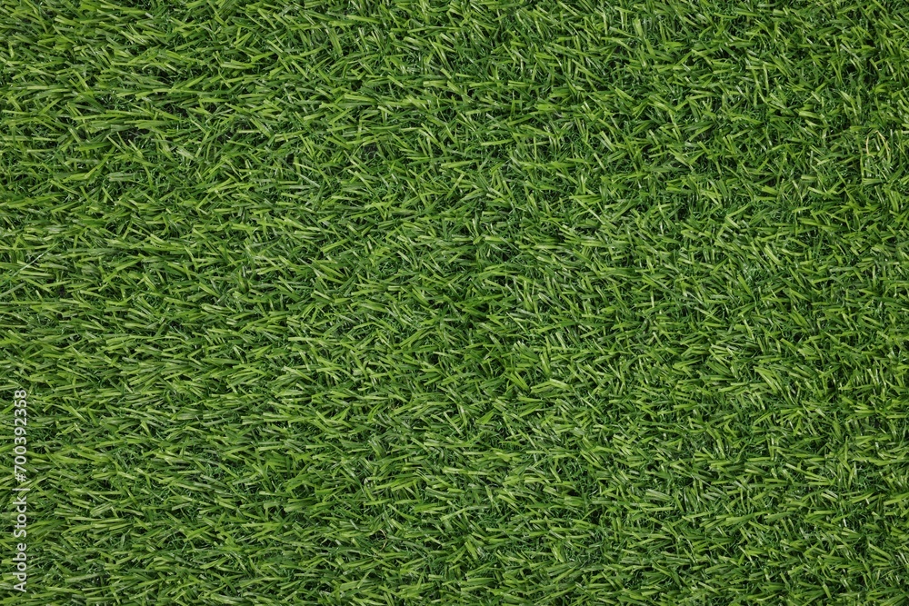 Fototapeta premium Green artificial grass as background, top view