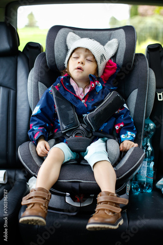 Enfant dormant sur son siège de voiture avec un bonnet fait à la main
