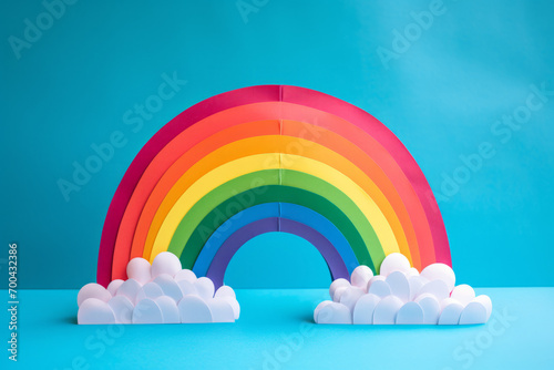 Close up photo of a papercraft rainbow, isolated on a solid blue background photo