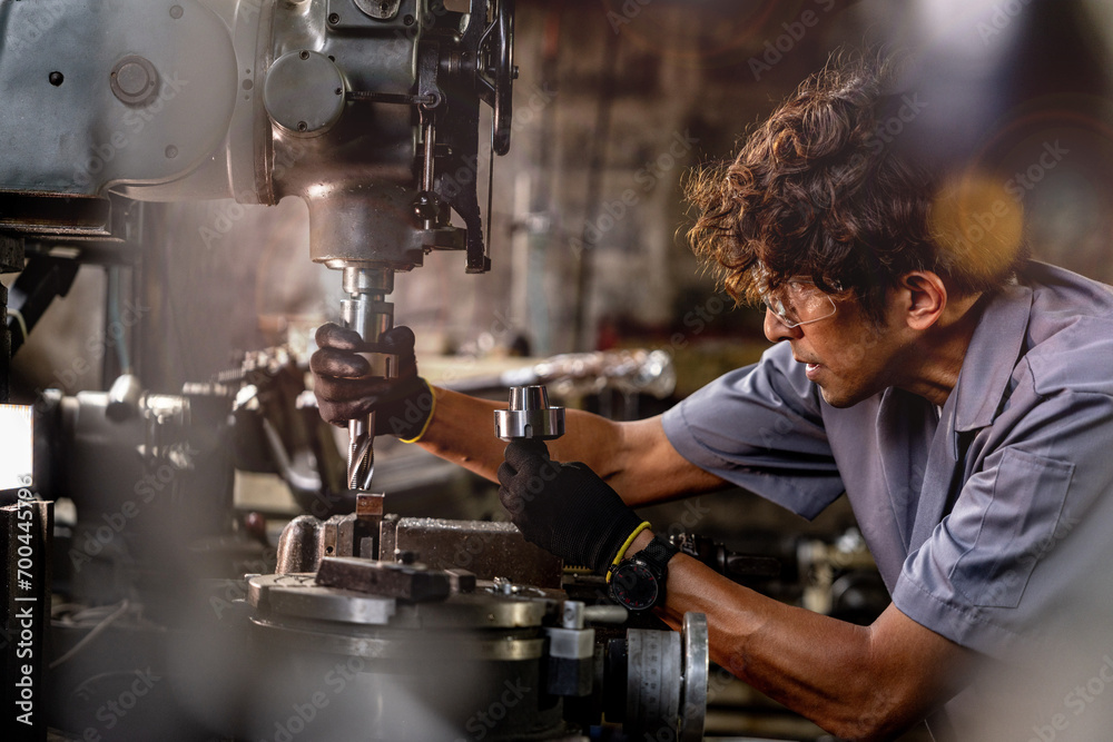 © ultramansk - Asian worker in production plant drilling at machine. Professional worker near drilling machine on factory. finishing metal working internal steel surface on lathe grinder machine with flying sparks. © ultramansk - Asian worker in production plant drilling at machine. Professional worker near drilling machine on factory. finishing metal working internal steel surface on lathe grinder machine with flying sparks.