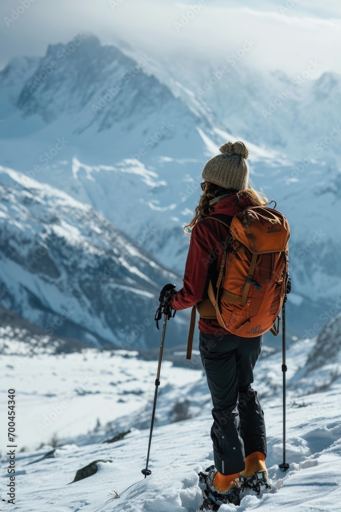 A person with a backpack and skis standing on a snowy mountain. Perfect for winter sports and adventure themes A person with a backpack and skis standing on a snowy mountain. Perfect for winter sports and adventure themes