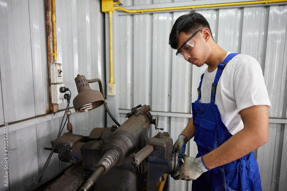 factory worker or technician checking lathe machine in factory
