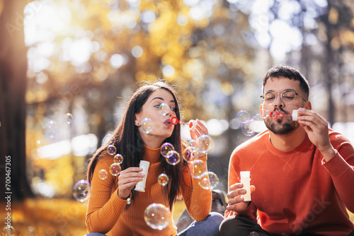 Young couple relaxing in the park with bubble blower. photo