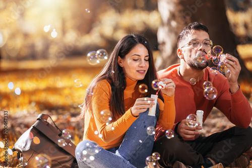 Young couple relaxing in the park with bubble blower.