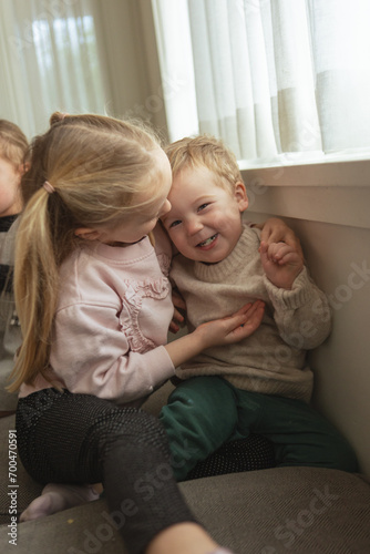 Brother and sister tickle each other during festive family morning