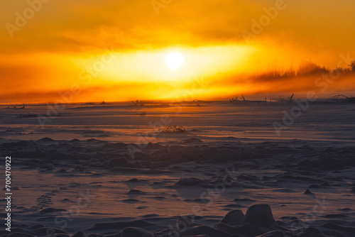 Sun sets over a frozen river in Alaska