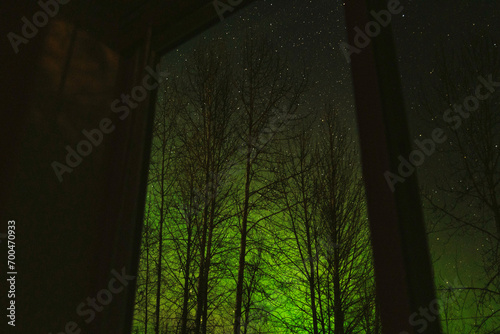 Stars and aurora borealis seen through a window in Alaska