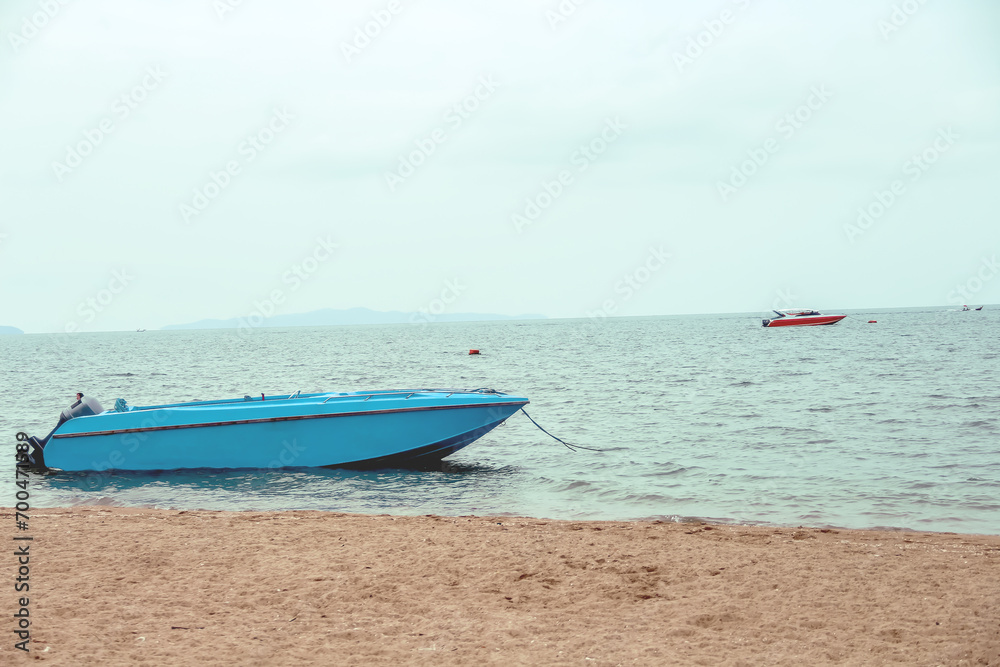 Blue boat moored in sea beach on sky and mountain view background