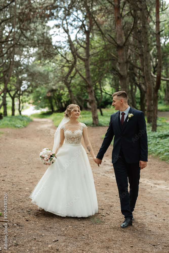 the groom and the bride are walking in the forest