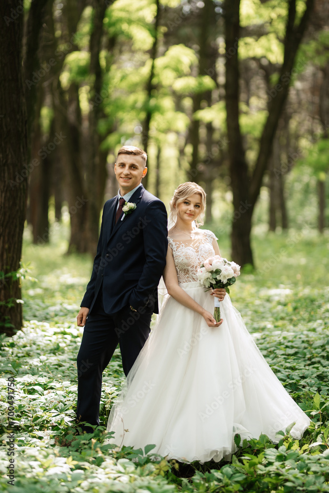 the groom and the bride are walking in the forest