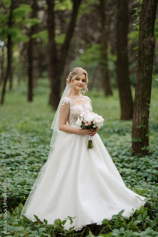 young girl bride in a white dress in a spring forest