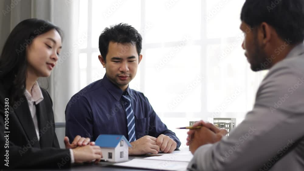 Businessman is negotiating a contract for the purchase and sale of a house. Real estate agent is offering a house for sale and a businessman signs an agreement document. Businessman is negotiating a contract for the purchase and sale of a house. Real estate agent is offering a house for sale and a businessman signs an agreement document.