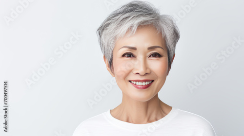 Elegant  smiling  elderly  chic Asian woman with gray hair and perfect skin on a white background banner.