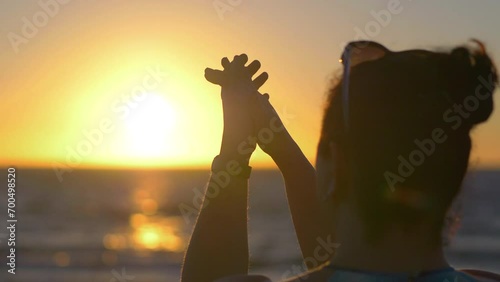 Woman clapping hands at sunset in 4k slow motion 60fps photo