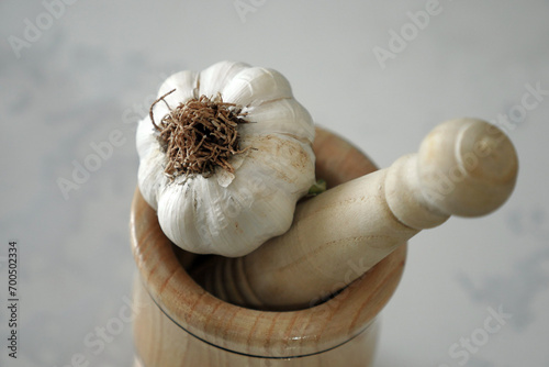 close-up of a wooden garlic mortar and whole garlic,