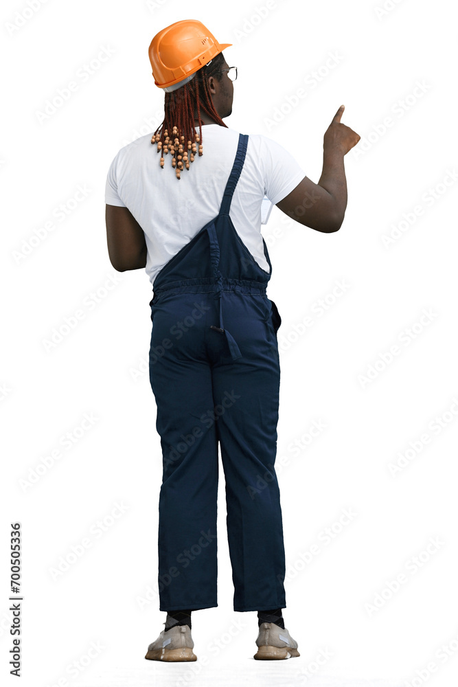 A man in a work uniform, on a White background, in full height, points to the side, back view