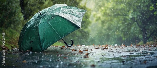 Broken green umbrella in park on rainy day with hail. Creative Banner. Copyspace image photo