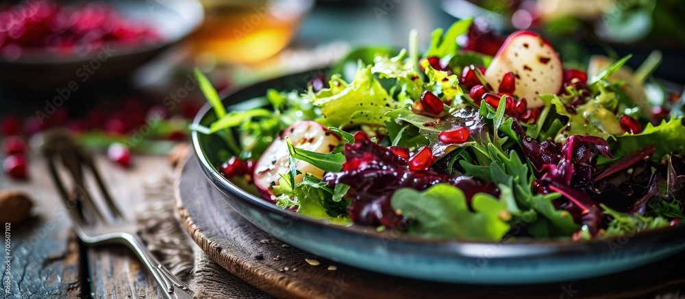 Colorful winter salad with mixed greens Belgian endives and pomegranate seeds. Creative Banner. Copyspace image