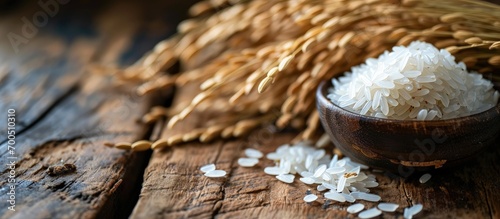 Cooked rice with dry ears of jasmine rice and wooden table. Creative Banner. Copyspace image photo