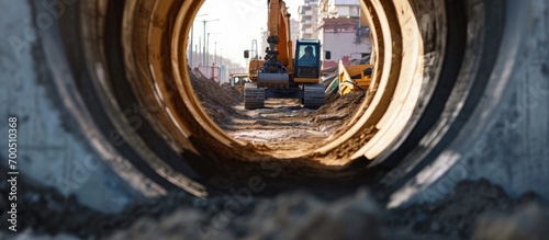 A large front loader pours sand into a pile at a construction site Transportation of bulk materials Construction equipment Bulk cargo transportation Excavation View from a large concrete pipe photo