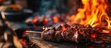 Large pieces of meat are baked and fried on spits Barbecue ham hock smoked meat grilled in an open fire flame in Oktoberfest. Creative Banner. Copyspace image