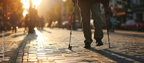 Close up of a blind man with a walking stick Walks on tactile tiles for self orientation while moving through the streets of the city. Creative Banner. Copyspace image photo