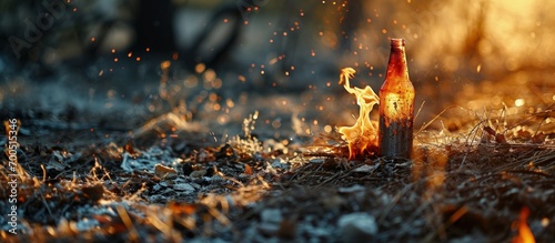 Abandoned beer can and alcohol bottle on the forest fire Dry grass burns ash. Creative Banner. Copyspace image © HN Works
