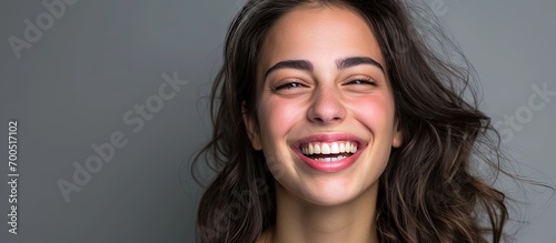 Happy excited woman showing pointing toothy smile Portrait of optimistic girl isolated over grey color background Optimism or Dental Health Care ad advertisement concept image Smiley face