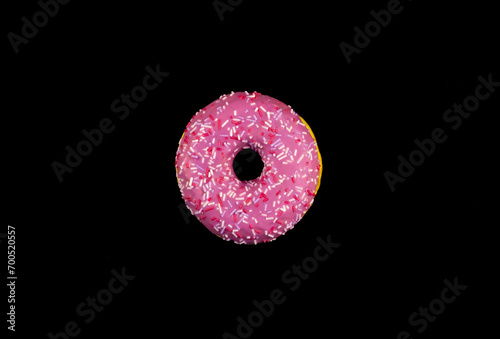 Pink donut on a black background © Valeria F