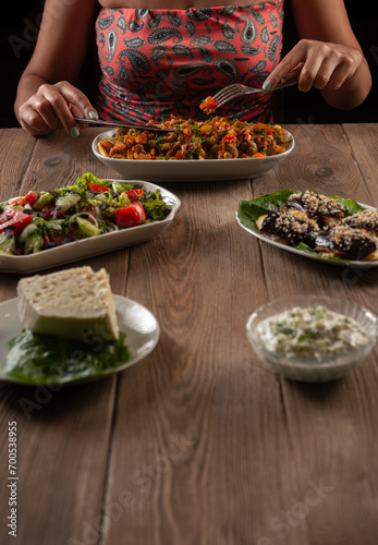 woman eat Traditional Armenian ,Turkish and Greek dinner appetizer platter on wooden table.