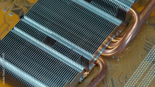 Powerful radiator with copper tubes for circulating coolant to cool the computer video card. Closeup. Macro. Shallow depth of field. Shot in motion photo