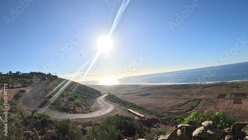 paragliding flying over scenic seaside landscape,timelapse,sand dunes and mountain terrain,aerial apnorama landscape view,paragliding pilot with his paraglider wing,aerial extreme sports,action camera photo