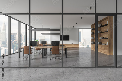 Glass coworking interior with desk and pc desktop in row, panoramic window photo