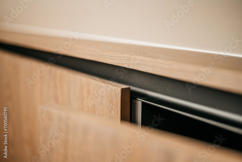 Close up of an oak wood cabinet door with black accents