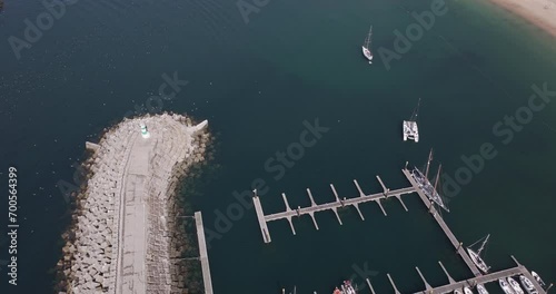 Aerial drone shot in Sines, Setúbal, Alentejo, Portugal, Europe. Drone flying above port and industrial zone, with birds circling end of pier. Shot in 5K ProRes 422HQ, exported in ProRes photo