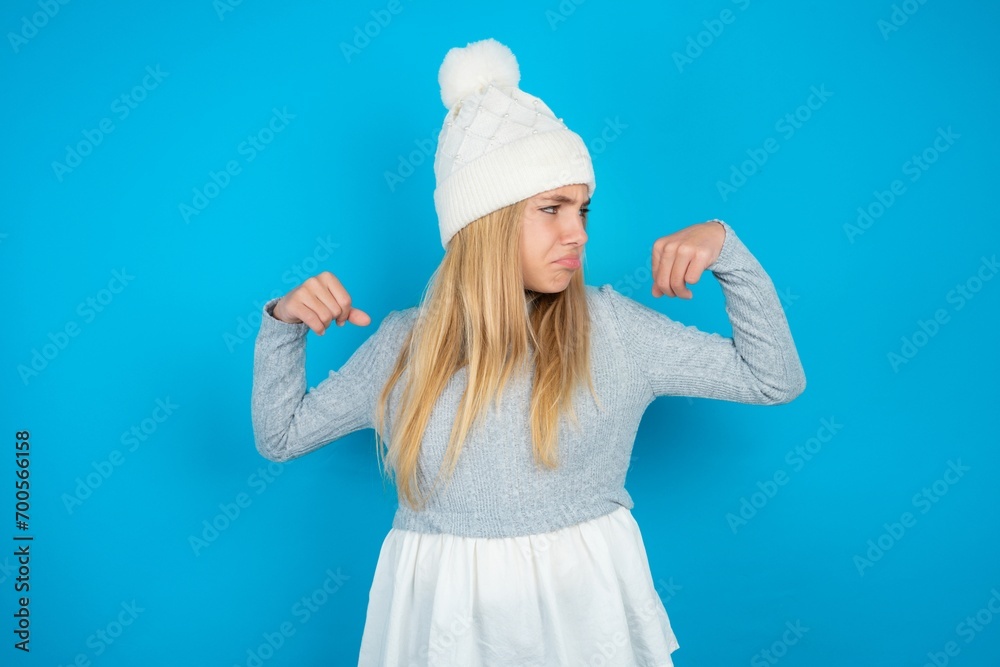 beautiful caucasian teen girl wearing grey sweater showing arms muscles smiling proud. Fitness concept. beautiful caucasian teen girl wearing grey sweater showing arms muscles smiling proud. Fitness concept.