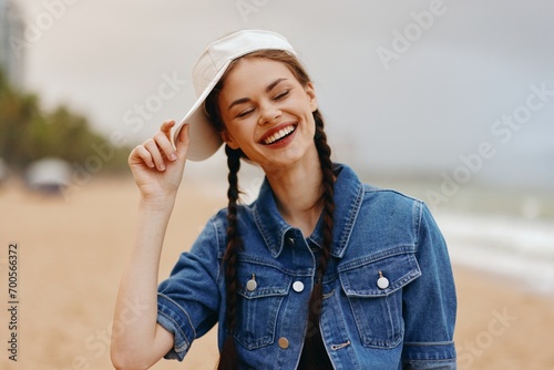 Smiling Young Woman in White Hat, Enjoying Sunny Summer Day in the Park, Exuding Happiness and Freedom © SHOTPRIME STUDIO